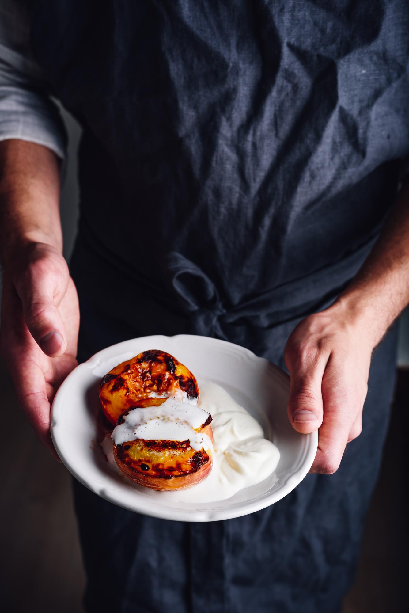 Chef plating a rustic plated dish with hands